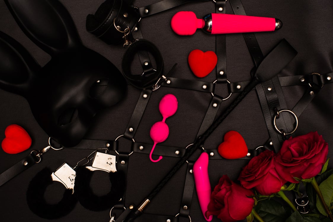 Set of adult toys on a dark background with red roses